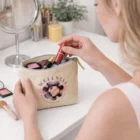 Woman with Eve Cosmetic Bags - Small removes lipstick at a vanity table.