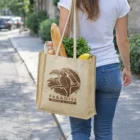 Person carrying a Tozana Juco Tote Bag with bread, greens, and a Paradise Bakery & Cafe logo.