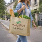 A person walks outdoors carrying groceries in a Ciella Juco Tote Bag.