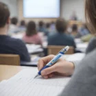 Student writes with Ball Pen And Highlighters during a classroom lecture.
