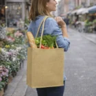 Woman with Laminated Jute Bags filled with groceries and a baguette at an outdoor market.