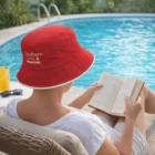 Poolside in an Outlast Bucket Hat, reading and sipping juice.