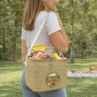 Woman with Mini Jute Cooler Bag carrying fruit and snacks at a picnic in the park.