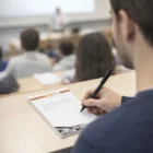 Student taking notes with Conello A6 Note Pads- 50 Leaves during a classroom lecture.