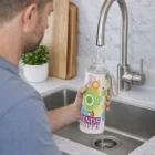 Filling a 600ml Glass Bottle With Full Colour Sleeve at the kitchen sink.