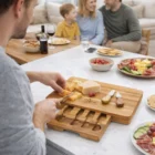 Someone slices cheese on a Provence Cheese Board; family gathers at table with snacks.