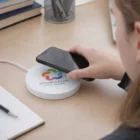 Person places a smartphone on a Volta Wireless Charger labeled DoubleStar Office Supplies.