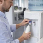 Man fills a Classic Powder Coated Bottle at an office water cooler.