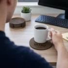 Person at a desk with a Costal Coasters Set Of 6 beside their coffee cup.