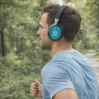 Man jogging outdoors in a blue shirt, wearing Deluxe Customised Noise Cancelling Headphones.