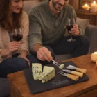 Two people share wine and cheese on Luxury Branded Slate Cheeseboard Sets in a cozy setting.
