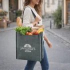 Woman carries groceries in a Reign Heather A4 Tote Bag filled with lettuce, bread, and bananas.