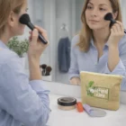 Denisse applies makeup by the mirror, her Denisse Cosmetic Bags on the counter.