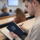 Man taking notes with a Moleskine Classic Soft Cover Notebook Large labeled YOUR LOGO HERE.