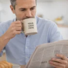 Man drinking from a 350Ml Wheat Fibre Logo Printed Mug while reading the newspaper at breakfast.