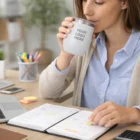 Woman sips from a Conner Vacuum Cup - Powder Coated while writing in her planner at her desk.