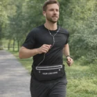 Man jogging in slim joggers and earphones, wearing a Slim Logo Printed Joggers Belt for essentials.