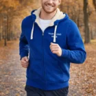 Man jogging outside in a blue Sols Sherpa Unisex Zipped Sweatshirt with Your Logo Here.