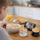 A boy eats cereal while watching a video on his phone with an Orkley Bamboo Phone Holder.