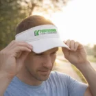 Man adjusts a Tactik Mesh Visor outdoors in sunlight.