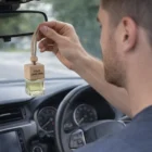 Man hanging Refillable Air Fresheners with customizable logo from the rearview mirror.