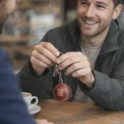 Smiling man holding Goulburn Cricket Ball Key Rings—YOUR LOGO HERE.