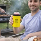 Smiling man holding a yellow Pilbara Vacuum Stubby Cooler with YOUR LOGO HERE printed on it.