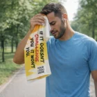Man in blue shirt wipes sweat with Enduro Poly Cotton Sports Towel that reads, If it doesn't challenge you.