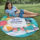 Young woman relaxing on a Round Poly Cotton Beach Towel in the park, listening to music.