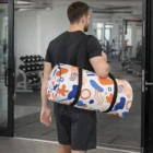 Man in workout clothes carrying Full Colour Sublimated Duffle Bag in a gym.