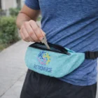 Person putting keys into a blue Vesta Polyester Waist Bag while standing outdoors.