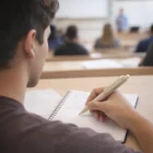 Student takes notes with Bamboo Grip Pens at their desk during a classroom lecture.