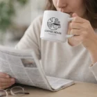 Woman sipping from Nevabrew Stackable Mugs while reading at a cozy table.