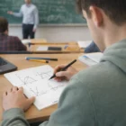 Students use Caspian Graph Note Pads A4 to draw graphs in class with teacher at chalkboard.