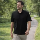 Man in Nike Dri-Fit Classic Polo and beige pants smiles while walking on a park path.