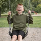 A smiling boy in a Youth Supply Hoodie swings at a park playground.