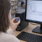 Person saves a file with a 16Gb Blossom Usb Stick at a library desktop computer.