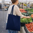 Woman with Coraline Cotton Canvas Convention Tote shops at an outdoor farmers market.