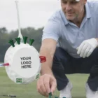 Golfer placing tees, featuring Corporate Bag Tags displaying YOUR LOGO HERE.