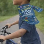 Child wears blue Aces Tubular Bandanas – Kids scarf with 'Summer Science Camp' and science images.