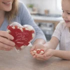 Smiling woman and child enjoy Hearts Jar Jelly Beans together at the table.