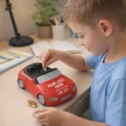 Smiling boy puts coins into a Convertible Coin Savings Bank on a desk.