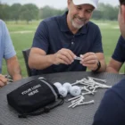 Smiling man with a golf tee at a table with golf balls and Vaulables Pouch Packs.
