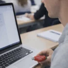 Person using a Chilli Flash Drive with a laptop in a classroom.