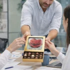 Man handing Corporate Chocolates Colour Mini Square Box with a rose and your logo on the lid.