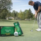 Man putting with Golf Balls Hot Bite; customizable box shown in the foreground.