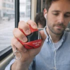 Man relaxing and listening to music while holding a Helmet Stress Ball keychain.
