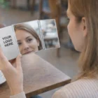Woman with Personalised Tri Mirrors at a table, drinking coffee.