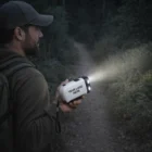 Man using Dynamo Flashlights on a forest trail at night, "Your Logo Here" displayed.