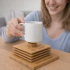 Smiling woman places a mug on Bamboo Coaster Sets stacked on the table.